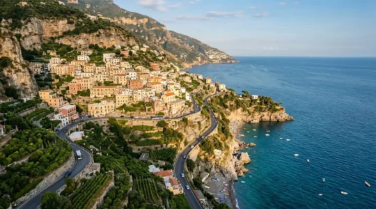 Scenic view of pastel-colored houses cascading down cliffs to turquoise Mediterranean waters