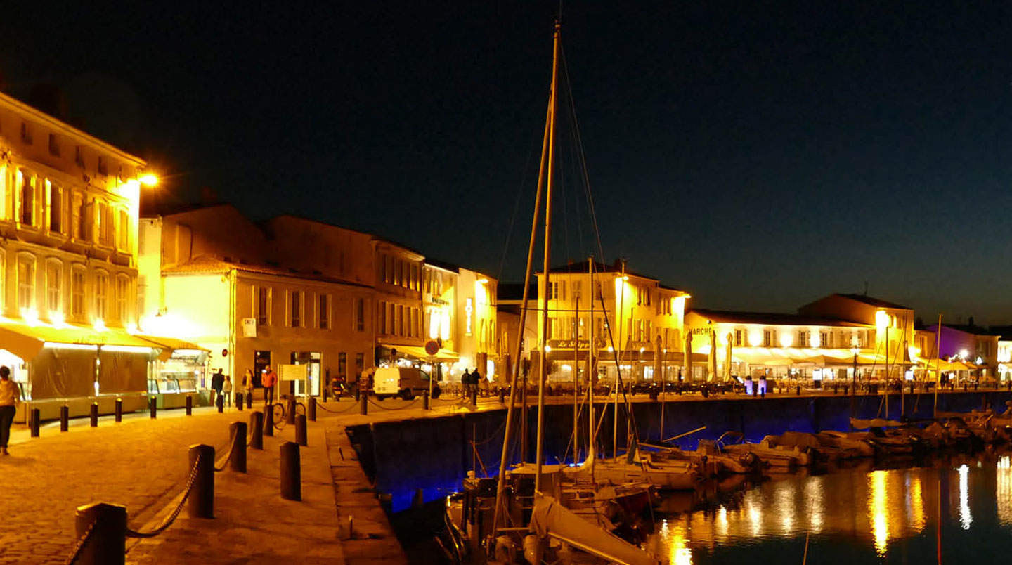 A quiet village street with typical Île de Ré architecture showing white walls and green shutters, a bicycle leaning against a wall, soft morning light