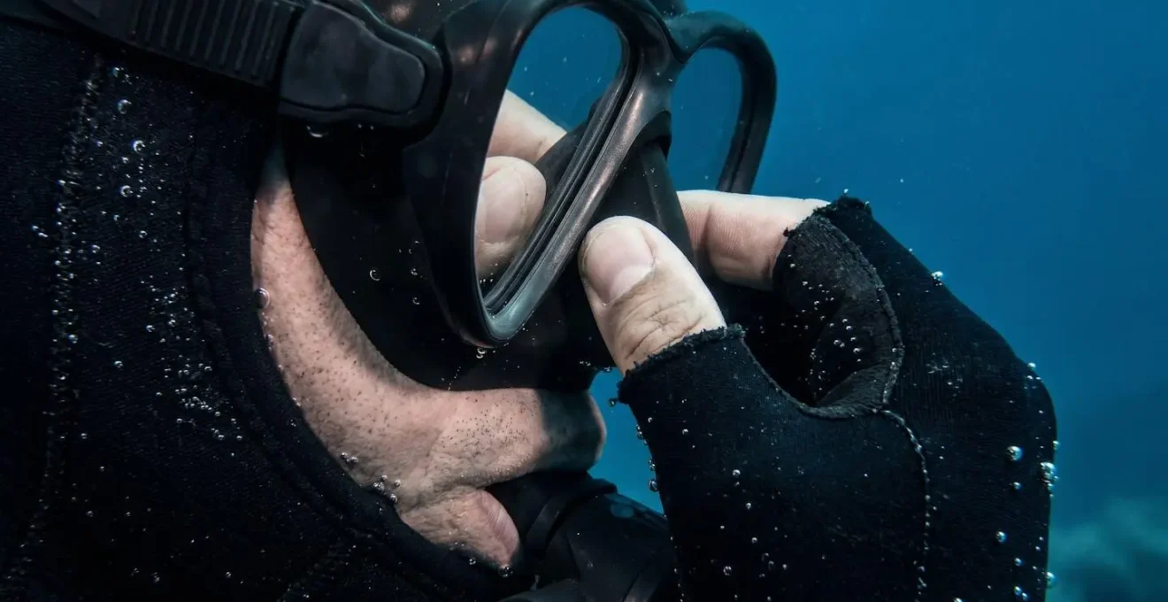 Close-up of diver demonstrating proper ear equalization technique at shallow depth
