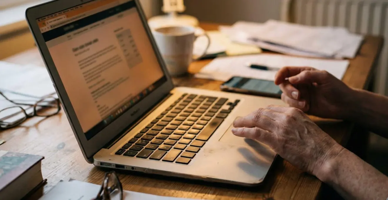 Hands holding a smartphone in a softly lit room, face not visible, appearing to scroll through images